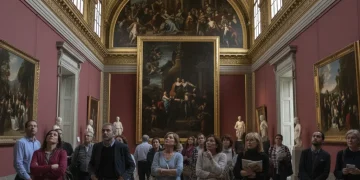 Visitantes admirando una obra maestra en un museo nacional español, reflejando la riqueza cultural de España.