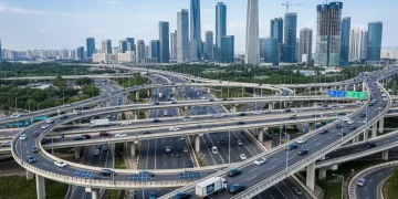 Modern highway infrastructure with bridges and city skyline, representing US infrastructure investment and economic development.